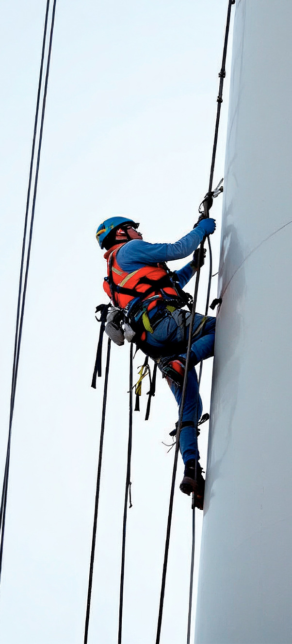 Instructor con casco explicando procedimientos seguros de trabajo en altura a un grupo